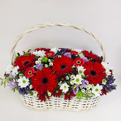 Яркая цветочная композиция в плетеной корзине в сочетании гербер и хризантемы