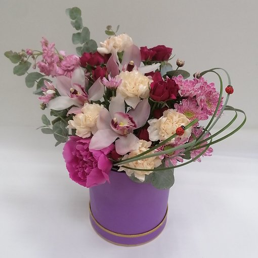 Композиция в декоративной шляпной коробке с элегантным цимбидиумом, кустовой розой, диантусом, малиолой, кустовой хризантемой и ароматной зеленью. 
